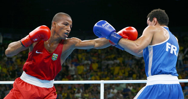 Robson Conceio golpeia o francs na luta que valeu o primeiro ouro do boxe brasileiro