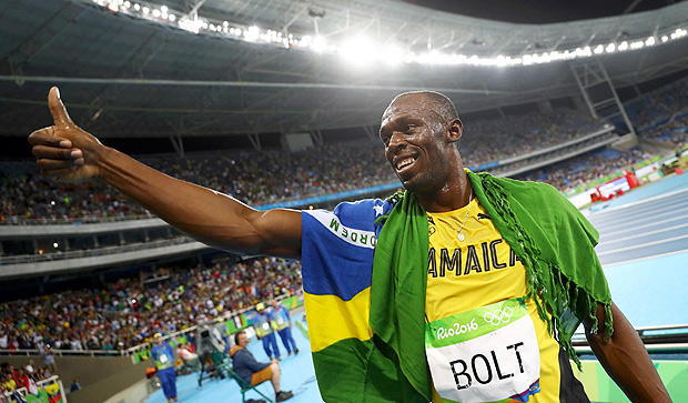 Bolt se enrolou na bandeira do Brasil depois de vencer o terceiro ouro