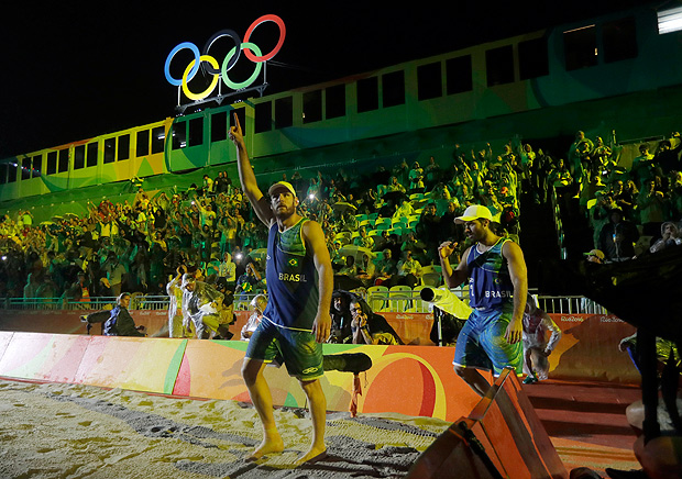 Brazil's Alison Cerutti, left, and teammate Bruno Oscar Schmidt are introduced before playing Italy in the men's beach volleyball gold medal match at the 2016 Summer Olympics in Rio de Janeiro, Brazil, Thursday, Aug. 18, 2016. (AP Photo/Marcio Jose Sanchez) ORG XMIT: OBVL140