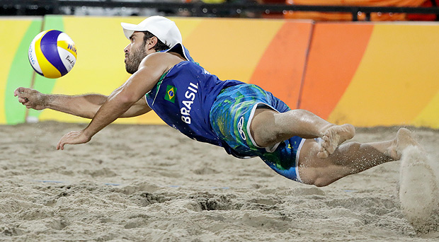 Brazil's Bruno Oscar Schmidt digs a ball while playing against Italy during the men's beach volleyball gold medal match at the 2016 Summer Olympics in Rio de Janeiro, Brazil, Friday, Aug. 19, 2016. (AP Photo/Marcio Jose Sanchez) ORG XMIT: OBVL145