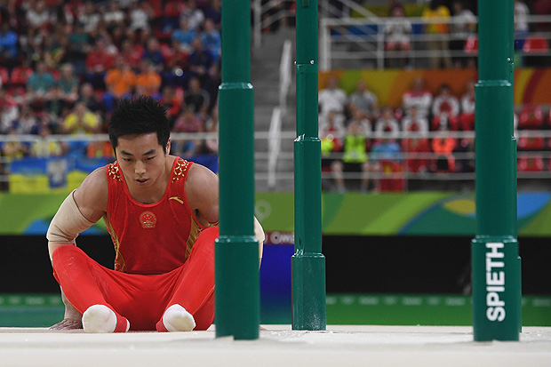 O ginasta chins You Hao lamenta queda nas barras paralelas durante a Rio-2016