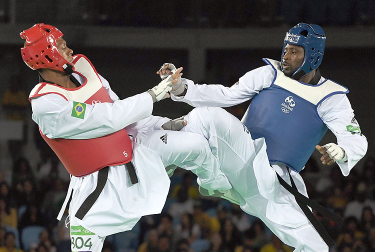 Great Britain's Mahama Cho (R) competes against Brazil's Maicon Siqueira during their men's taekwondo bronze medal bout in the +80kg category as part of the Rio 2016 Olympic Games, on August 20, 2016, at the Carioca Arena 3, in Rio de Janeiro. / AFP PHOTO / Ed JONES