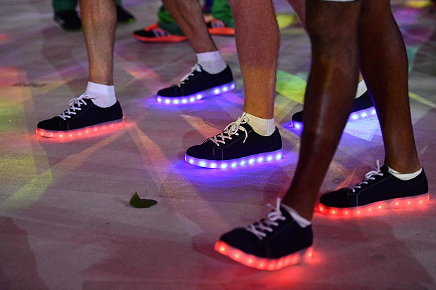 A close up image shows people wearing shoes with light-decoration marching during the closing ceremony of the Rio 2016 Olympic Games at the Maracana stadium in Rio de Janeiro on August 21, 2016. / AFP PHOTO / Leon NEAL