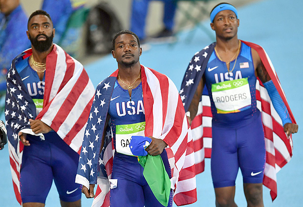 (LtoR) USA's Tyson Gay, USA's Justin Gatlin and USA's Michael Rodgers react after being disqualified of the Men's 4x100m Relay Final during the athletics event at the Rio 2016 Olympic Games at the Olympic Stadium in Rio de Janeiro on August 19, 2016. / AFP PHOTO / PEDRO UGARTE