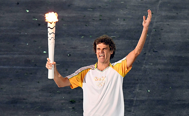 Brazilian tennis player Gustavo Kuerten carries the Olympic flame during the opening ceremony of the Rio 2016 Olympic Games at the Maracana stadium in Rio de Janeiro on August 5, 2016. / AFP PHOTO / GABRIEL BOUYS