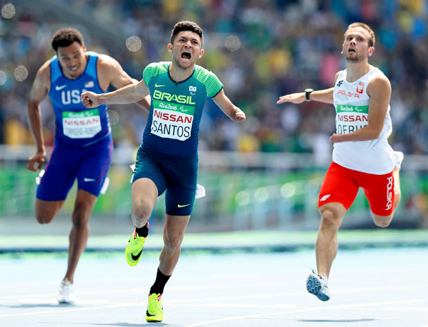 2016 Rio Paralympics - Men's 100m - T47 Final - Olympic Stadium - Rio de Janeiro, Brazil - 11/09/2016. Petrucio Ferreira dos Santos of Brazil celebrates setting a new world record and winning the gold medal in the event as Michal Derus of Poland (R) takes the silver. REUTERS/Jason Cairnduff FOR EDITORIAL USE ONLY. NOT FOR SALE FOR MARKETING OR ADVERTISING CAMPAIGNS. ORG XMIT: OLYHB04