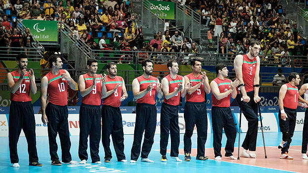 Iran's tallest sitting volleyball player Morteza Mehrzadselakjani (2nd-R) stands with teammates before a preliminary match agasint Ukraine in the Paralympic Games at Riocentro in Rio de Janeiro on September 14, 2016. / AFP PHOTO / YASUYOSHI CHIBA