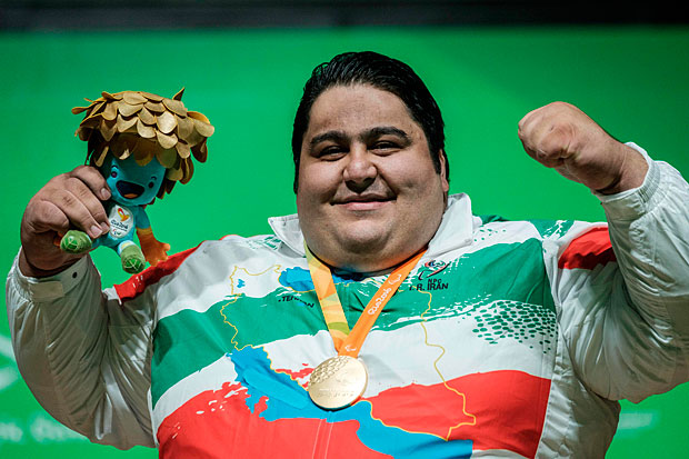 Iran's Siamand Rahman poses with his gold medal during the medal ceremony for men's powerlifting +107 kg (group A) during the Paralympic Games at the Riocentro in Rio de Janeiro, Brazil on September 14, 2016. / AFP PHOTO / YASUYOSHI CHIBA