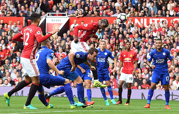 Manchester United's French midfielder Paul Pogba (C) heads in their fourth goal during the English Premier League football match between Manchester United and Leicester City at Old Trafford in Manchester, north west England, on September 24, 2016. / AFP PHOTO / ANTHONY DEVLIN / RESTRICTED TO EDITORIAL USE. No use with unauthorized audio, video, data, fixture lists, club/league logos or 'live' services. Online in-match use limited to 75 images, no video emulation. No use in betting, games or single club/league/player publications. /