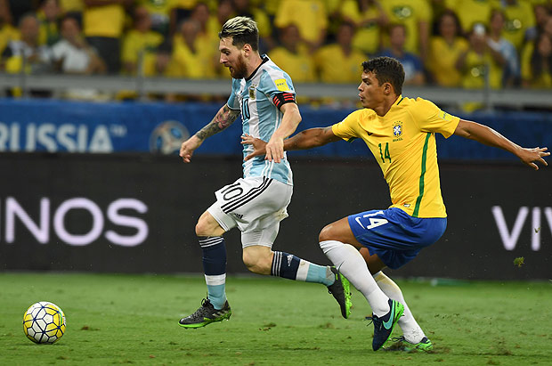 O zagueiro Thiago Silva tenta desarmar Messi 