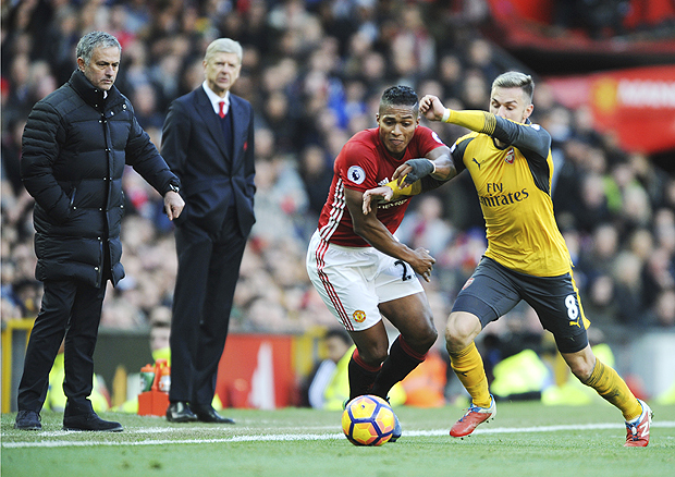 Manchester United's Antonio Valencia, left, and Arsenal's Aaron Ramsey battle for the ball during the English Premier League soccer match between Manchester United and Arsenal at Old Trafford in Manchester, England, Saturday, Nov. 19, 2016. (AP Photo/Rui Vieira) ORG XMIT: BRV125
