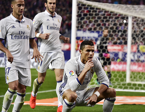 Real Madrid's Portuguese forward Cristiano Ronaldo (R) celebrates with Real Madrid's midfielder Lucas Vazquez (L) and Real Madrid's Welsh forward Gareth Bale after scoring during the Spanish league football match Club Atletico de Madrid vs Real Madrid CF at the Vicente Calderon stadium in Madrid, on November 19, 2016. / AFP PHOTO / GERARD JULIEN ORG XMIT: GJ6901