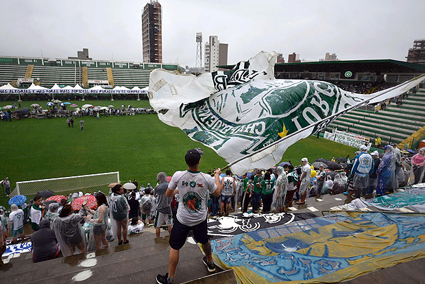 People await for the arrival of the funeral cortege of the players of Brazilian football team Chapecoense Real killed in a plane crash in the Colombian mountains, at the Arena Conda stadium in Chapeco, in the southern Brazilian state of Santa Catarina, on December 3, 2016. The first of two Brazilian air force planes carrying the remains of a football team killed in a plane crash arrived Saturday in the city of Chapeco in southern Brazil. / AFP PHOTO / DOUGLAS MAGNO