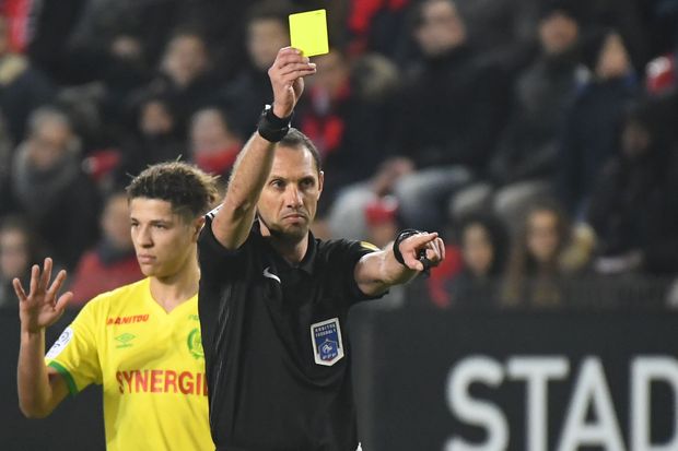 O árbitro Mikael Lesage mostra cartão amarelo durante partida do Campeonato Francês