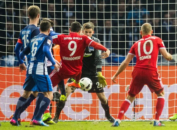 Munichs Polish forward Robert Lewandowski (C) scores during the German First division Bundesliga football match Hertha Berlin vs Bayern Munich in Berlin, eastern Germany, on February 18, 2017. / AFP PHOTO / ROBERT MICHAEL / RESTRICTIONS: DURING MATCH TIME: DFL RULES TO LIMIT THE ONLINE USAGE TO 15 PICTURES PER MATCH AND FORBID IMAGE SEQUENCES TO SIMULATE VIDEO. == RESTRICTED TO EDITORIAL USE == FOR FURTHER QUERIES PLEASE CONTACT DFL DIRECTLY AT + 49 69 650050 / RESTRICTIONS: DURING MATCH TIME: DFL RULES TO LIMIT THE ONLINE USAGE TO 15 PICTURES PER MATCH AND FORBID IMAGE SEQUENCES TO SIMULATE VIDEO. == RESTRICTED TO EDITORIAL USE == FOR FURTHER QUERIES PLEASE CONTACT DFL DIRECTLY AT + 49 69 650050