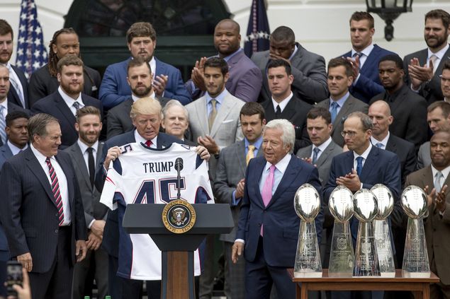 President Donald Trump is presented with a New England Patriots jersey by Patriots head coach Bill Belichick, left, and New England Patriots owner Robert Kraft, center, during a ceremony on the South Lawn of the White House in Washington, Wednesday, April 19, 2017, where the president honored the Super Bowl Champion New England Patriots for their Super Bowl LI victory. Also pictured is New England Patriots president Jonathan Kraft, second from right. (AP Photo/Andrew Harnik) ORG XMIT: DCAH110
