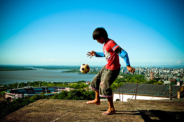 Crianas se divertem jogando bola em laje de barraco no alto do morro Santa Teresa, em Porto Alegre (RS)