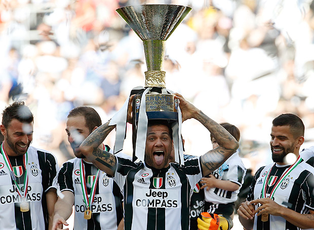 Juventus' Dani Alves lifts the trophy as Juventus players celebrate winning an unprecedented sixth consecutive Italian title, at the end of the Serie A soccer match between Juventus and Crotone at the Juventus stadium, in Turin, Italy, Sunday, May 21, 2017. (AP Photo/Antonio Calanni) ORG XMIT: XAC119