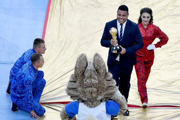Brazilian former footaball player Ronaldo holds the trophy as the he greeted by Zabivaka, the Official Mascot for the 2018 FIFA World Cup Russia, prior to the start of the 2017 Confederations Cup final football match between Chile and Germany at Saint Petersburg Stadium in Saint Petersburg on July 2, 2017. / AFP PHOTO / YURI CORTEZ