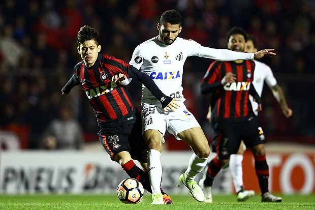 Rossetto from Brazil's Atletico Paranaense struggles for the ball with Thiago Maya (R) from Brazil's Santos during their 2017 Libertadores Cup football match at Vila Capanema stadium in Curitiba, Brazil on July 5, 2017. / AFP PHOTO / Heuler Andrey