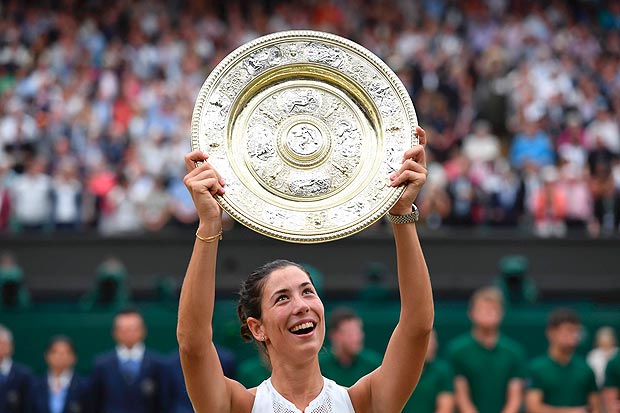 Spain's Garbine Muguruza holds up The Venus Rosewater Dish as she celebrates beating US player Venus Williams to win the women's singles final on the twelfth day of the 2017 Wimbledon Championships at The All England Lawn Tennis Club in Wimbledon, southwest London, on July 15, 2017. Muguruza won 7-5, 6-0. / AFP PHOTO / Glyn KIRK / RESTRICTED TO EDITORIAL USE