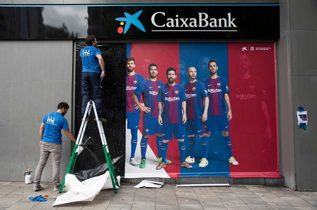 Funcionrios removem a imagem de Neymar em anncio do lado de fora do Camp Nou, estdio do Barcelona