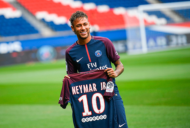 Brazilian superstar Neymar poses with his new jersey during his official presentation at the Parc des Princes stadium on August 4, 2017 in Paris after agreeing a five-year contract following his world record 222 million euro ($260 million) transfer from Barcelona to Paris Saint Germain's (PSG). Paris Saint-Germain have signed Brazilian forward Neymar from Barcelona for a world-record transfer fee of 222 million euros (around $264 million), more than doubling the previous record. Neymar said he came to Paris Saint-Germain for a 