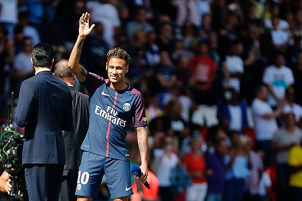 Paris Saint-Germain's Brazilian forward Neymar waves to the crowd as he arrives on the football field during his presentation to the fans at the Parc des Princes stadium in Paris, on August 5, 2017. Brazil superstar Neymar will watch from the stands as Paris Saint-Germain open their season on August 5, 2017, but the French club have already clawed back around a million euros on their world record investment. Neymar, who signed from Barcelona for a mind-boggling 222 million euros ($264 million), is presented to the PSG support prior to his new team's first game of the Ligue 1 campaign against promoted Amiens. / AFP PHOTO / Thomas Samson