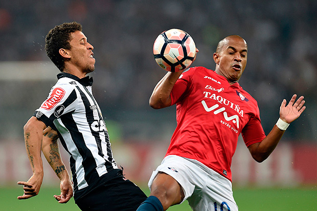 Marcos Rocha (L) of Brazil's Atletico Mineiro, vies for the ball with Serginho (R) of Bolivia's Jorge Wilstermann, during their 2017 Copa Libertadores match held at Mineirao stadium, in Belo Horizonte, Brazil, on August 9, 2017. / AFP PHOTO / DOUGLAS MAGNO