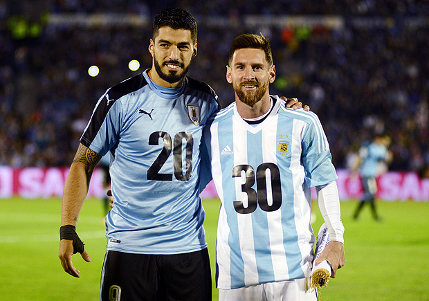 Soccer Football - 2018 World Cup Qualifiers - Uruguay v Argentina - Centenario stadium, Montevideo, Uruguay - August 31, 2017. Argentina's Lionel Messi and Uruguay's Luis Suarez pose wearing jerseys to promote their countries joint bid to host the 2030 World Cup finals. REUTERS/Carlos Pazos