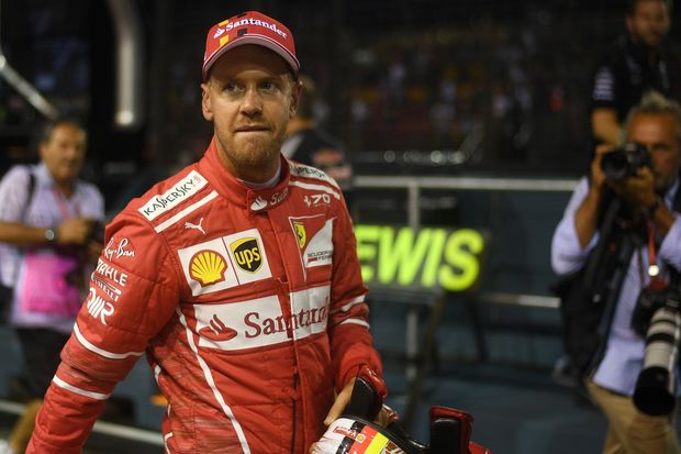 Ferrari's German driver Sebastian Vettel walks back after taking pole position in the qualifying session of the Formula One Singapore Grand Prix in Singapore on September 16, 2017. / AFP PHOTO / Manan VATSYAYANA ORG XMIT: MV524