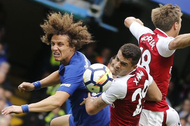 Chelsea's David Luiz, Arsenal's Granit Xhaka, and Arsenal's Nacho Monreal, from left, jump to head the ball during the English Premier League soccer match between Chelsea and Arsenal at Stamford Bridge stadium in London, Sunday, Sept. 17, 2017. (AP Photo/Frank Augstein) 