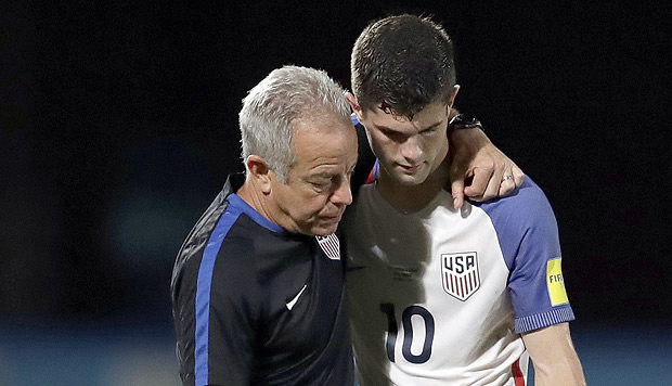 United States' Christian Pulisic, right, is comforted by a member of the team staff after the U.S. lost to Trinidad and Tobago in their World Cup qualifying match, at Ato Boldon Stadium in Couva, Trinidad and Tobago, Tuesday, Oct. 10, 2017. (AP Photo/Rebecca Blackwell) ORG XMIT: MXRB103