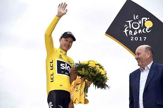 (FILES) This file photo taken on July 23, 2017 shows Tour de France 2017's winner Britain's Christopher Froome celebrating his overall leader yellow jersey on the podium at the end of the 103 km twenty-first and last stage of the 104th edition of the Tour de France cycling race between Montgeron and Paris Champs-Elysees.Froome, four-time winner of the Tour de France, has been tested positive for the bronchodilator 'Salbutamol' during the 2017 Tour of Spain that he won, the International Cycling Union (UCI) said in a statement on December 13, 2017. / AFP PHOTO / Jeff PACHOUD