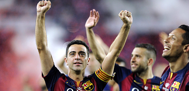 Xavi acena para torcedores na época em que atuava no Barcelona