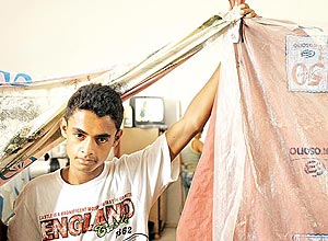 Eliel Luis da Silva, 18, mostra os panos que dividem os quartos de cada famlia