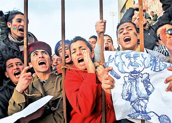 manifestantes com desenho de Gaddafi