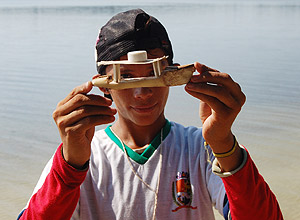 Garoto da comunidade Vila do Mximo, em Parintins (AM), segura barquinho feito de aninga 