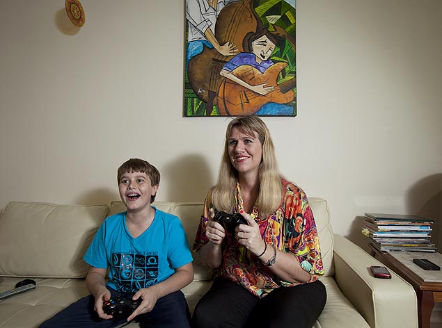 Ivan, 9, joga videogame com sua mãe, Gisele