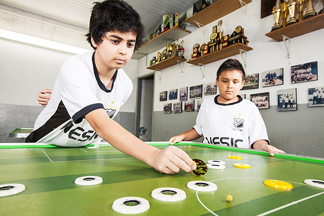 Guilherme Gomes, 12, se prepara para chutar uma bola com seu time de futebol de boto, em que jogadores so estrelas do rock