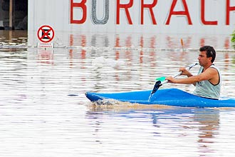 Homem usa caiaque para passar por inundao em Santa Catarina; oito cidades foram isoladas devido s chuvas que atingem o Estado