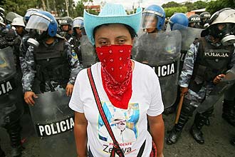 Fabiola Carcamo, 28, usa lenço para cobrir o rosto em um dos protestos em favor de Zelaya na capital Tegucigalpa