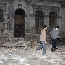 Chilenos caminham em meio aos escombros causados pelo terremoto que atingiu o pas
