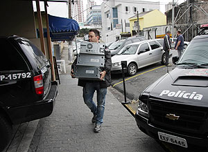 Policial do Garra de Guarulhos (Grande São Paulo) carrega computadores de vereadores apreendidos nesta sexta-feira