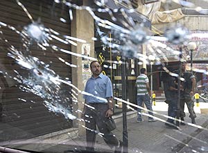 Libaneses so vistos por vidro de carro baleado em rea residencial de Beirute aps embates entre grupos rivais