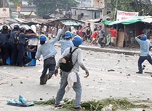 Equipe de demolição joga pedras em retribuição aos ataques de moradores de favela ilegal em Manila, nas Filipinas 