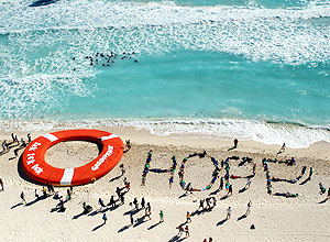 Ativistas ambientais fazem manifestao durante conferncia em Cancn; na areia, v-se a palavra "hope" (esperana