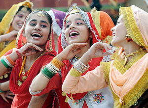 Estudantes indianas usam o tradicional vestido Punjabi para uma apresentação de dança folclórica no colégio