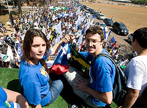 Líder estudantil chilena Camila Vallejo (esq) posa ao lado de Daniel Ilescu, presidente da UNE, com protesto ao fundo