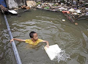 Garoto brinca em área inundada em Bangcoc, na Tailândia; país está em 37º lugar na lista dos países com maior risco